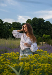 Obraz premium woman in a field of yellow and blue flowers
