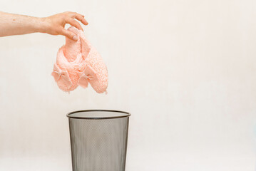 The slippers is thrown into the trash for disposal and recycling.White,gray background,selective...