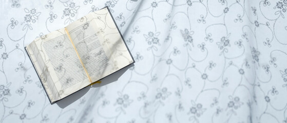 open book on a white background in the morning sunlight.