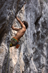 Strong man climbing a rock.