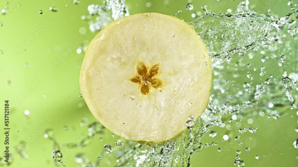 Aufkleber slice of apple with water splashes on green background.