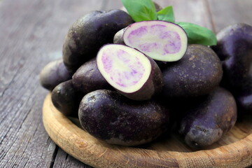 potatoes purple fresh crop close-up on wooden surface selective focus, organic vegetables