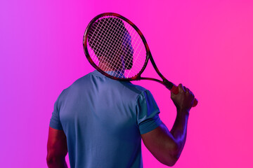 Image of back view of african american male tennis player in violet and pink neon lighting