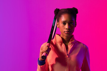 Image of african american female tennis player in violet and pink neon lighting