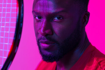 Image of african american male tennis player in neon pink lighting