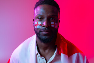 Image of serious african american male soccer fan with flag of england in neon pink lighting