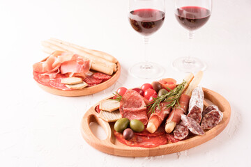 Charcuterie plate with different types of meat snacks - salami, bresaola, proscuitto. Wooden plates...