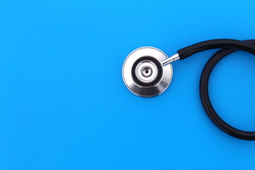 Fototapeta na wymiar The stethoscope lies on a blue background.