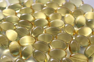 Background, capsules of vitamin D transparent yellow.