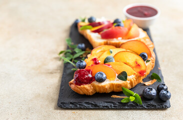 Vegetarian croissant sandwiches with nectarine, soft or cream cheese, blueberries and honey. Healthy breakfast or lunch.