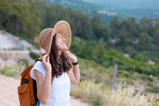 young girl in a straw hat and a backpack.