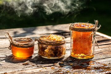 Natural honey comb and a glass jar on wooden table. Honey background. Sweet honey. Long banner...