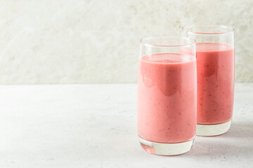 Strawberry banana smoothie, yogurt milkshake in glass with mint leaves.