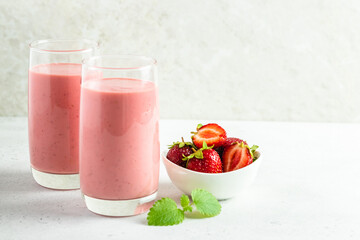Strawberry oatmeal coconut milk smoothie, yogurt milkshake in glass with mint leaves.