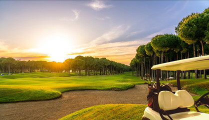 Panorama of golf cart on beautiful golf course at sunset