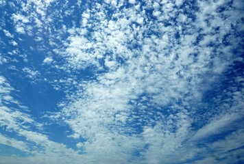 Fototapeta na wymiar Blauer Himmel mit weißem Wolkengebilde bei Sonne am Mittag im Sommer