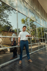 A young businessman man near the glass facade