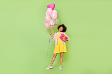 Full length portrait of positive pretty person hold balloons giftbox isolated on green color background