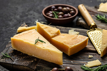 Sliced and grated parmesan cheese with rosemary on a gray table, banner, menu, recipe place for text, top view