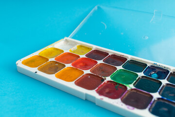 Brushes, painting tools and paints on a blue background