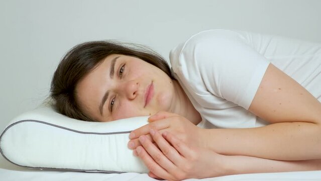 A woman gets up with an orthopedic pillow made of memory foam, the pillow takes its former shape