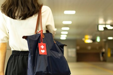 ヘルプマークをつけた若い女性