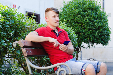 Young handsome man, tourist walking in summer park, old city. Phone call. Technology. Social media. Vacation