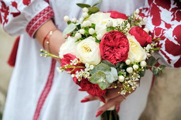 Bride in ukrainian suit holding a beautiful bouquet