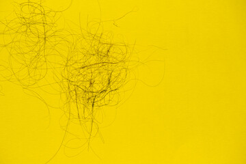 Fallen hair on the yellow background. Baldness and hair loss problem