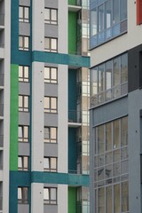 Full-color vertical photo. Urban landscape. Linear geometric composition of parts of facades of city buildings. A wall with windows and corners.