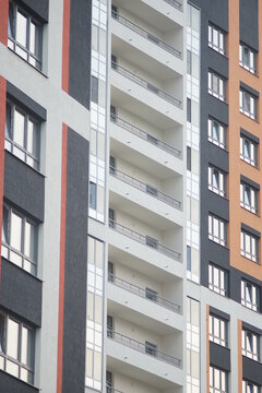 Full-color vertical photo. Urban landscape. Linear geometric composition of parts of facades of city buildings. A wall with windows and corners.