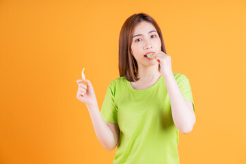 Photo of young Asian girl eating snack on background