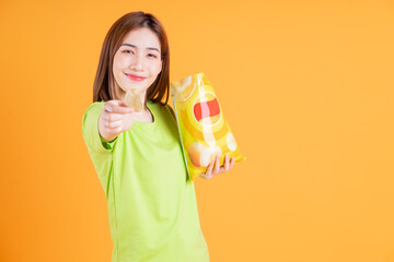 Photo of young Asian girl eating snack on background