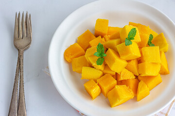 Fresh Ripe Mango Cubes on a Plate with a Fork Top Down Fresh Fruit photo