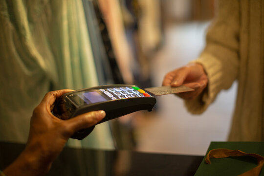Close up customer with credit card paying at credit card reader