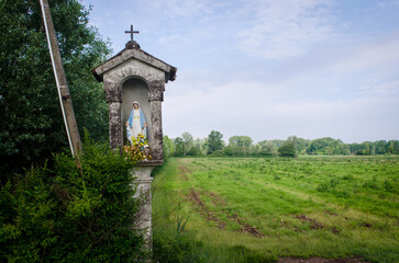 Obraz premium Un piccolo tabernacolo dedicato alla madonna lungo la Via Postumia, cammino che parte da Aquileia e arriva a Genova