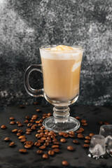 There is a glass of coffee on the black napkin on the grey table in the cafe.