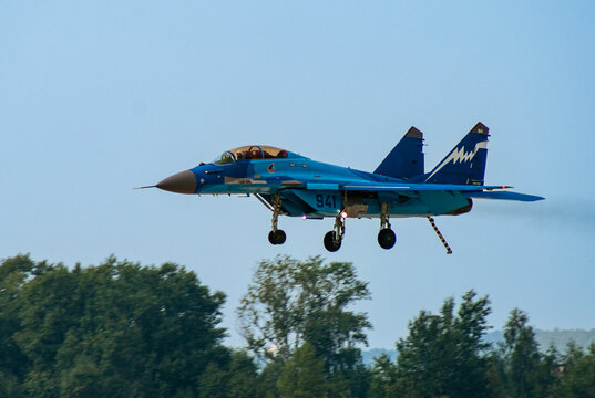 Russian carrier-based multi-role fighter MiG-29K (NATO - Fulcrum-D) comes in for landing over trees. Landing gear and landing hook released. Blurred background. Zhukovsky, Russia - August 22, 2007