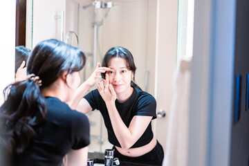 コンタクトレンズを装着する若い女性