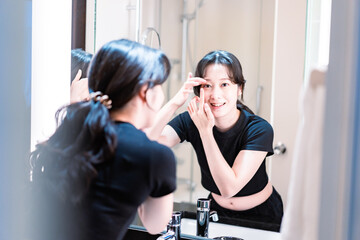 コンタクトレンズを装着する若い女性