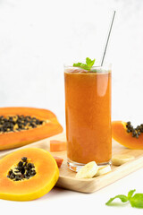 Papaya and banana smoothie with fresh fruits on white background