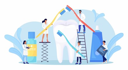Stomatology, dentistry. Tiny Dentists standing around big tooth and cleaning, treating unhealthy teeth with caries cavity. Doctors brushing, clean plaque. Dental examination. Dentist appointment