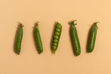 Green peas on a beige background. Top view.