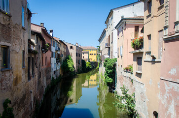 Fototapeta na wymiar Un canale fra le case storiche di Mantova lungo la Via Postumia, cammino che parte da Aquileia e arriva a Genova