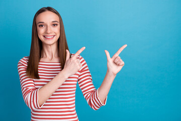 Photo of sweet young woman dressed shirt smiling pointing finger empty space isolated blue color background
