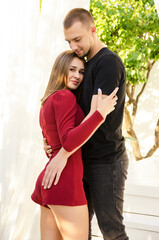 Naklejka premium beautiful sexy young couple standing in tropical garden near pool and hugging