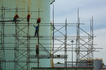 Worker male assembly in progress storage new tank  oil inspection scaffolding