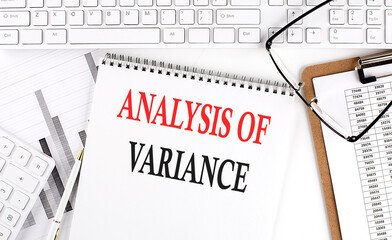 Text ANALYSIS OF VARIANCE on Office desk table with keyboard, notepad and analysis chart on white...