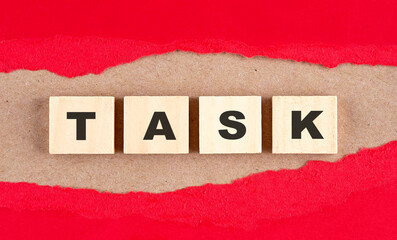 TASK word on wooden cubes on red torn paper , financial concept background