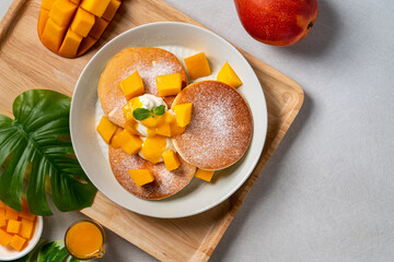 Delicious Japanese souffle pancake with dice mango and jam on white table background.